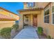 Inviting home entrance with a charming porch, brown door, and lovely landscaping at 1178 Yellow Orchid St, Henderson, NV 89002