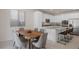 Open-concept kitchen and dining area with modern appliances, granite counters, island seating, and stylish dining table at 12521 Lylan Ridge St, Las Vegas, NV 89138