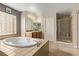 Elegant bathroom featuring a soaking tub, tiled flooring, and a glass-enclosed shower at 1436 Via Merano St, Henderson, NV 89052