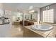 Well-lit bathroom with a large soaking tub, dual vanities, and neutral color palette at 1436 Via Merano St, Henderson, NV 89052