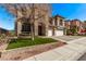 Inviting two-story home featuring a three-car garage, stone accents, and a beautifully landscaped front yard at 1436 Via Merano St, Henderson, NV 89052