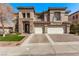 A lovely two-story home with a three-car garage, manicured lawn, and stone accents at 1436 Via Merano St, Henderson, NV 89052