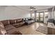 Bright living room boasting wood floors, balcony access, and a contemporary sectional sofa at 1436 Via Merano St, Henderson, NV 89052