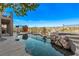 Luxury outdoor pool with a rock waterfall and spa against the backdrop of blue skies at 1436 Via Merano St, Henderson, NV 89052