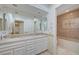 Bathroom featuring a double sink vanity and a shower-tub combo with glass doors at 208 Stonewood, Las Vegas, NV 89107