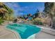 A refreshing backyard pool with clear blue water surrounded by lush landscaping and ample patio space at 208 Stonewood, Las Vegas, NV 89107