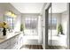 Bright bathroom with a white double vanity, soaking tub, and modern fixtures at 2108 Running River Rd, Henderson, NV 89074