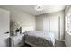 Cozy bedroom featuring a comfortable bed, modern light fixture, and a window with a view to outside at 2108 Running River Rd, Henderson, NV 89074