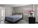 Inviting bedroom with wood floors, a bed with blue covers, a window and a walk-in bathroom at 2108 Running River Rd, Henderson, NV 89074