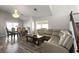 Open living space with wood floors, large sectional sofa and adjacent dining area under a chandelier at 2108 Running River Rd, Henderson, NV 89074