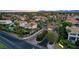 Aerial view of a gated community entrance with manicured landscaping, mature trees, and well-maintained street at 2508 Monarch Bay Dr, Las Vegas, NV 89128