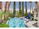 Backyard pool area featuring a basketball hoop, lounge seating, and lush trees at 2508 Monarch Bay Dr, Las Vegas, NV 89128