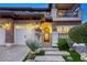 Grand entrance with stone steps, wrought iron gate, lush landscaping, and well-lit pathway to the front door at 2737 Josephine Dr, Henderson, NV 89044