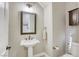 Comfortable powder room with a pedestal sink, a decorative mirror, and neutral decor for a welcoming space at 2737 Josephine Dr, Henderson, NV 89044