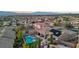 An aerial view of a neighborhood featuring a pool, desert landscaping, mountain views, and solar panels at 2809 Proust Ct, Henderson, NV 89044