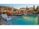 Resort-style backyard featuring a sparkling pool, hot tub, lush landscaping, and comfortable lounge chairs at 2809 Proust Ct, Henderson, NV 89044