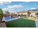Inviting backyard with a swimming pool and spa, a covered patio and artificial grass at 2809 Proust Ct, Henderson, NV 89044