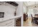 Modern bar area with wine refrigerator, white countertops and view to the dining room at 2809 Proust Ct, Henderson, NV 89044