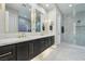 Bathroom featuring a double sink vanity, modern lighting, and a glass-enclosed shower with marble-style walls at 2809 Proust Ct, Henderson, NV 89044