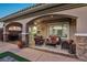 Relaxing covered patio with comfortable seating, stone pillars, and a seamless transition to the outdoors at 2809 Proust Ct, Henderson, NV 89044