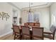 Dining room with modern light fixture, wood table with upholstered chairs, and decorative wall art at 2809 Proust Ct, Henderson, NV 89044
