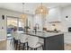 Stylish kitchen featuring a large island with seating, white cabinets, and modern lighting fixtures at 2809 Proust Ct, Henderson, NV 89044