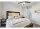 Spacious main bedroom with a plush bed, ceiling fan and a view into ensuite bath at 2809 Proust Ct, Henderson, NV 89044
