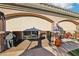 Covered patio with retractable shades, showcasing an outdoor kitchen and lounge area for versatile entertainment options at 2809 Proust Ct, Henderson, NV 89044