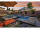 Beautiful backyard pool and lounging area with umbrellas, greenery, and brick pavers at sunset at 2809 Proust Ct, Henderson, NV 89044