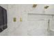 Close-up of a shower with marble-style walls, gold fixtures, and a built-in shelf at 2809 Proust Ct, Henderson, NV 89044