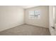 An empty bedroom features neutral carpet, a window with blinds, and a white door at 2813 Riverside Gold Ct, North Las Vegas, NV 89086