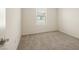An empty bedroom features neutral carpet, a window with blinds, and a white door at 2813 Riverside Gold Ct, North Las Vegas, NV 89086