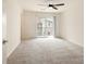 An empty bedroom features neutral carpet, a sliding glass door to a balcony, and a ceiling fan at 2813 Riverside Gold Ct, North Las Vegas, NV 89086