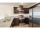 Modern kitchen featuring granite countertops, stainless steel appliances, and dark wood cabinetry at 2813 Riverside Gold Ct, North Las Vegas, NV 89086