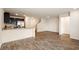 Bright living area with luxury vinyl plank floors, a kitchen bar, and staircase access at 2813 Riverside Gold Ct, North Las Vegas, NV 89086
