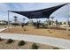 Community playground featuring swings, slides, and climbing structures, shaded by a large sun sail at 2813 Riverside Gold Ct, North Las Vegas, NV 89086