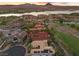 A sprawling estate with a red tile roof sits in a golf community near a lake, with scenic mountain views at 3 Rue Allard Way, Henderson, NV 89011