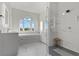 Bright bathroom with a soaking tub under an arched window and a glass-enclosed shower at 3 Rue Allard Way, Henderson, NV 89011