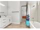 Bright bathroom with white cabinets, bathtub with shower, and view into an adjacent bedroom at 3 Rue Allard Way, Henderson, NV 89011