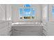 Close-up of soaking tub with marble surround under window with bright sky views at 3 Rue Allard Way, Henderson, NV 89011