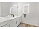 Bright bathroom featuring white cabinets, light fixtures, large mirror, and wood floors at 3 Rue Allard Way, Henderson, NV 89011