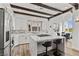 Bright kitchen features an island with counter seating, stainless steel appliances, white cabinets, and wood beam ceiling details at 3 Rue Allard Way, Henderson, NV 89011