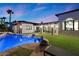 Inviting backyard pool area features a covered patio, lush green lawn, and beautifully designed landscaping at 3 Rue Allard Way, Henderson, NV 89011