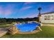Beautiful inground pool with grass surround, rock features, and lush landscaping at 3 Rue Allard Way, Henderson, NV 89011