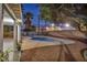 Backyard swimming pool surrounded by gravel and a concrete walkway. There's a block wall for privacy and mature landscaping at 3731 Spencer St, Las Vegas, NV 89119