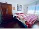 Bedroom with a floral comforter, wood dresser, and hardwood floors at 3856 Commanche Ave, Las Vegas, NV 89121