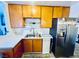 Traditional kitchen features wood cabinets, stainless steel refrigerator, and a double basin sink at 3856 Commanche Ave, Las Vegas, NV 89121