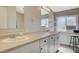 Bathroom featuring dual sinks, white cabinets, a large mirror, and natural light at 425 Bonelli Ave, Overton, NV 89040