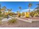 Expansive front yard with mature palm trees, lush greenery, and a charming fountain at 4471 Borrego Springs Way, Las Vegas, NV 89129