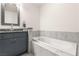 Bright bathroom featuring a vanity with granite countertop and tiled soaking tub at 4575 Dean Martin Dr # 1103, Las Vegas, NV 89103
